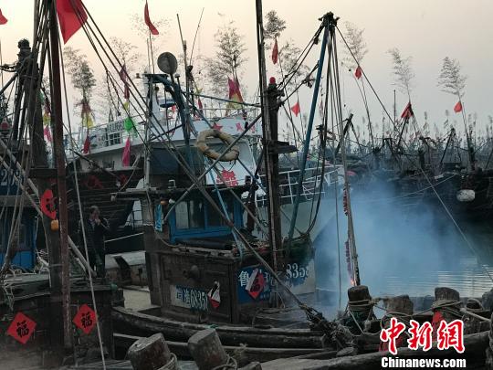 “财神日”当天,渔民在船上祭拜“龙王”放鞭炮。 郭亚楠 摄