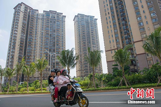 10月10日,市民在海口市区某地产项目前路过。 <a target='_blank' href='http://www.chinanews.com/' _fcksavedurl='http://www.chinanews.com/'></table>中新社</a>记者 骆云飞 摄