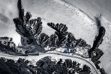 吕美玲+13899561865+《一径崎岖入谷中》-2023年12月摄于新疆红山大峡谷 ，白雪掩映的峡谷万壑争奇、千壑竞秀，仿佛一个巨大的叶脉覆盖大地，一辆红色的轿车在峡谷中穿行，给大地带来勃勃生机。_副本.jpg